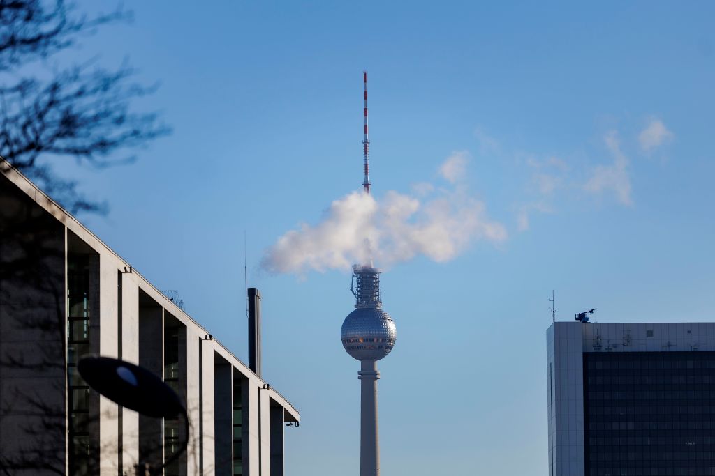The TV tower of Berlin covered by emissions from a chimney.